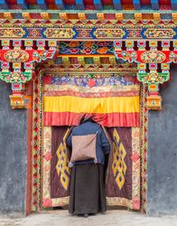 Tibet - August, 29 2014: Anonymous woman entering temple