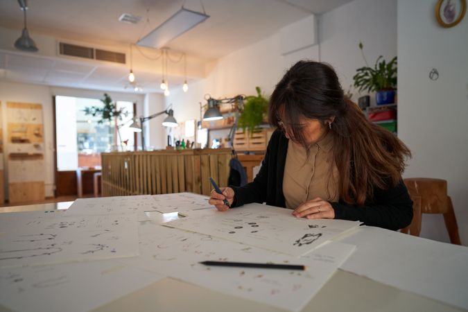 Serious designer painting sketches of accessories