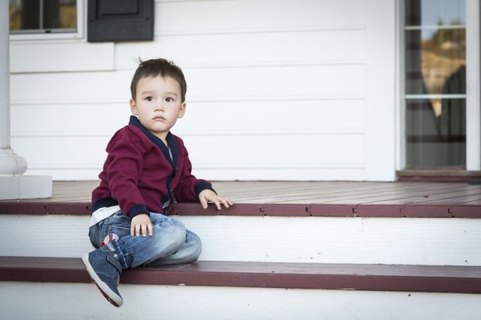 Melancholy Boy Sitting on Front Porch Steps