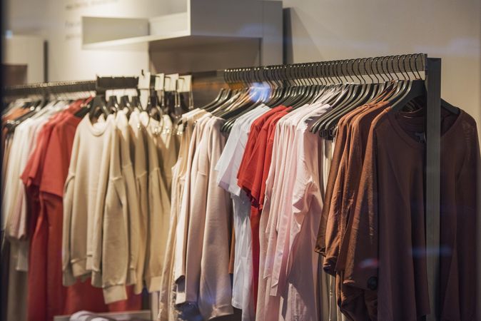 Clothes racks of casual shirts and sweaters in fashion store