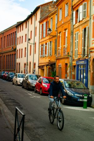Man riding a bicycle near residential houses
