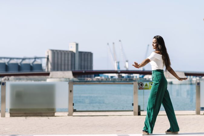 Young woman walking dancing on city street on daylight