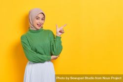 Excited woman in headscarf pointing her finger towards the side 41LZ75