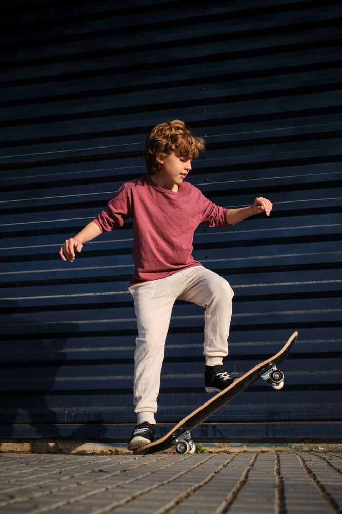 Little skater doing trick on street
