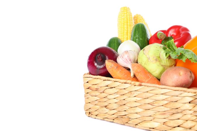 Wicker basket with vegetables isolated on blank background