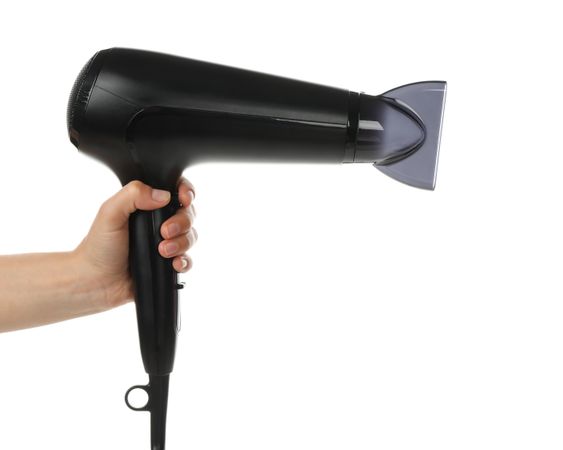 Female hand holds hair dryer, isolated on blank background