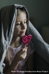 Profile view of young girl with a pink lollipop 0gXeN5