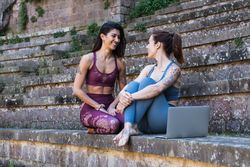 Smiling women sitting on stairs after yoga lesson