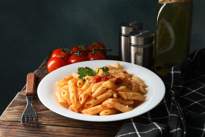 Composition with plate of tasty pasta on wooden background. Cooking pasta