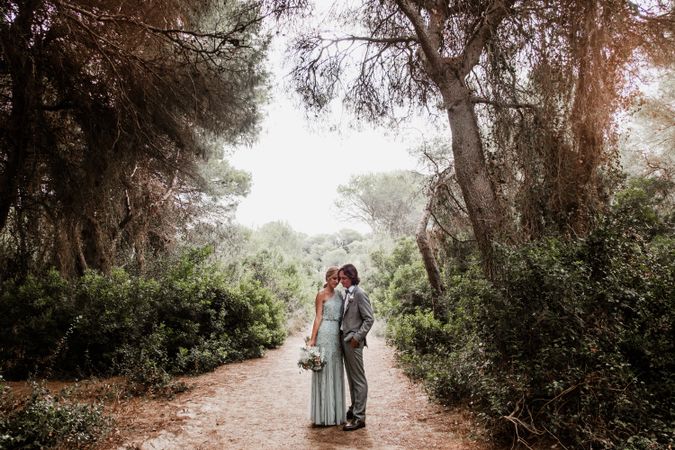 Happy married couple in wedding clothing at forest