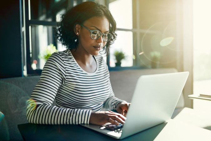 Focused woman working at laptop in cafe
