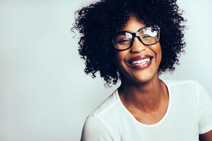 Studio portrait of laughing woman in oversized glasses