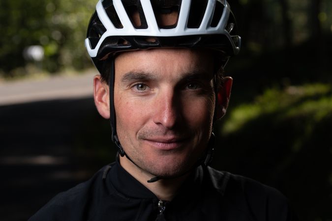 Positive cyclist looking at camera in park