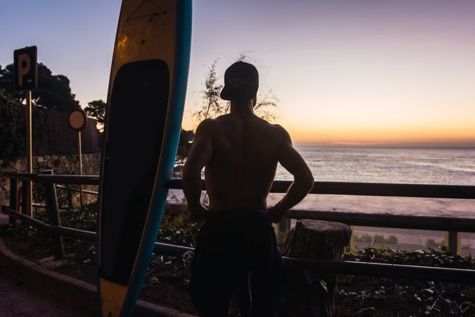 Man practicing paddle surfing with neoprene in a sunrise