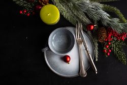 Top view of grey plate and mug surrounded by seasonal branch