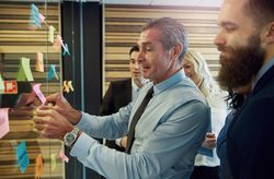 Mature businessman brainstorming with team