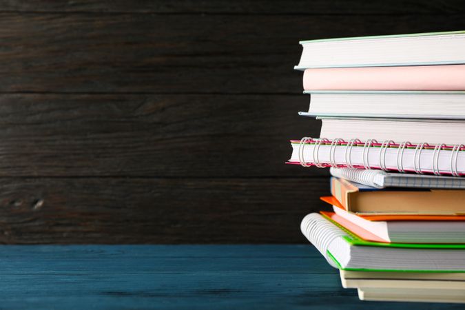 Composition with copybooks on wood table against dark background