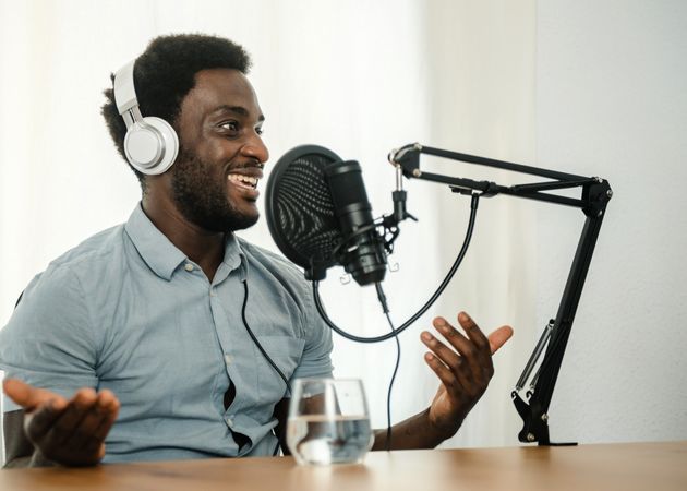 Black man recording podcast and gesticulating