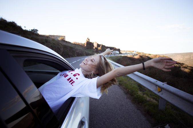 Blonde woman leaning out of car window