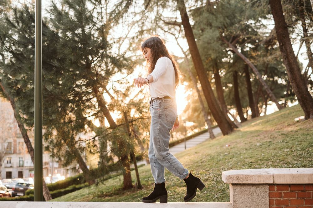 Young woman walking on border in park