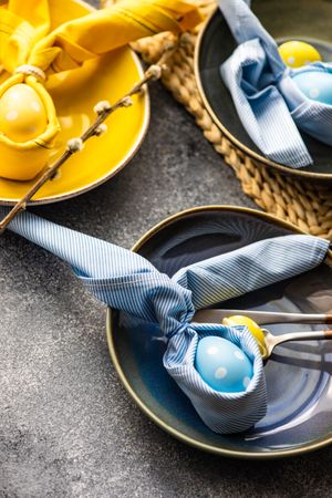 Easter holiday table setting with decorative blue and yellow eggs