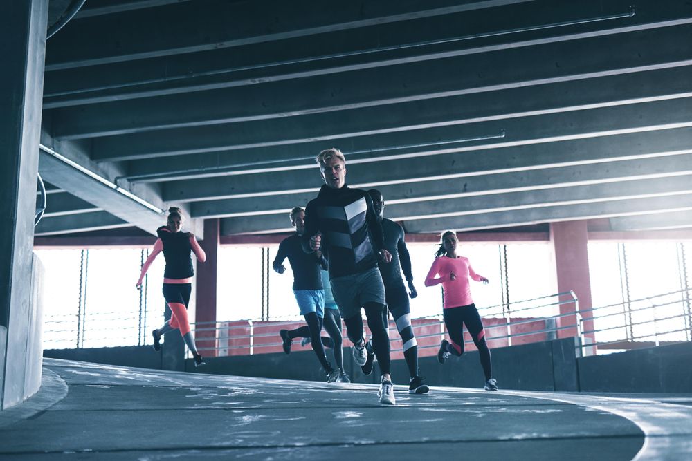 Group of people running around curve on concrete track