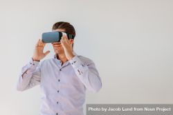 Shot of young man in virtual reality headset looking at the objects bDVo85