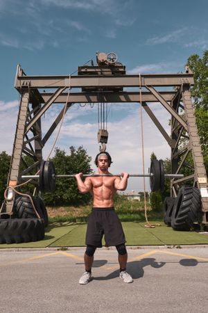 man with barbell in outdoor gym
