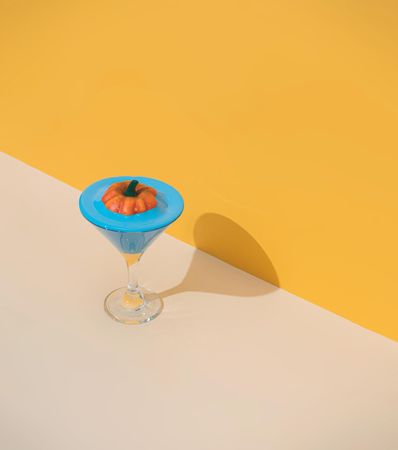 Mini pumpkin floating in a blue cocktail