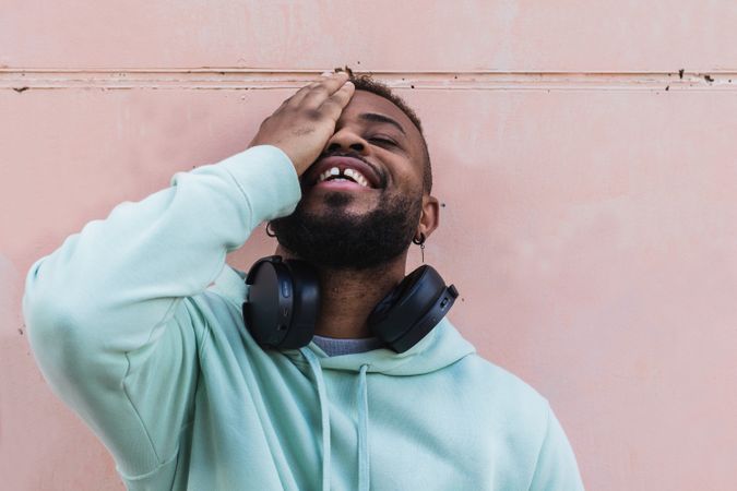 Delighted hipster man covering eye