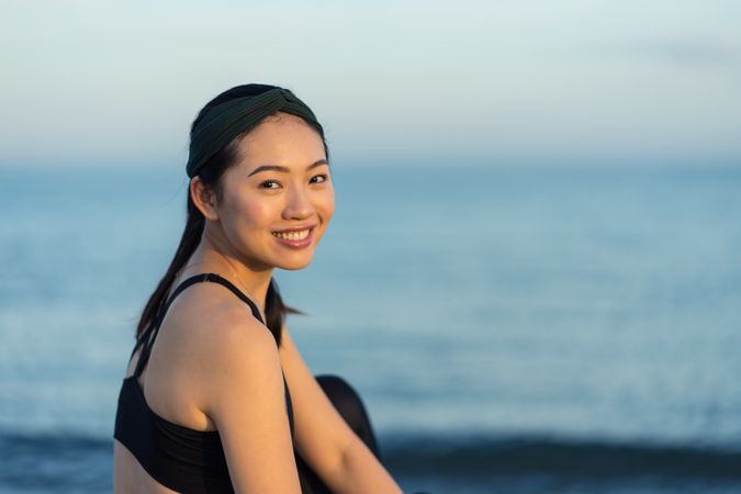 Sportive woman sitting in the on beach
