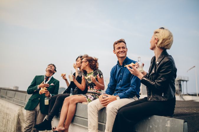 Young men and women enjoying drinks on rooftop