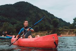 Young female kayaking on nature background