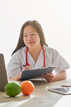 Content Asian doctor video chatting with patient