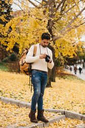 Trendy male with backpack and camera