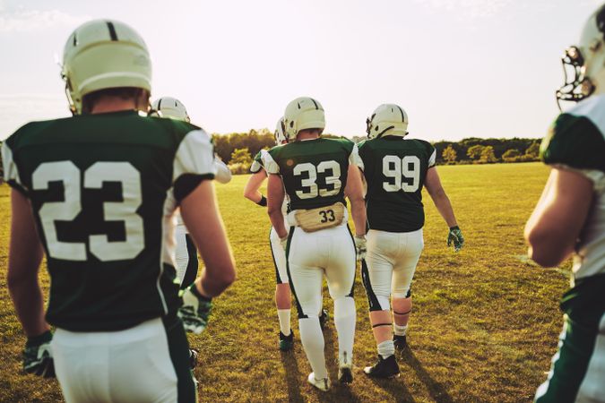 Rearshot of football team walking together on the field