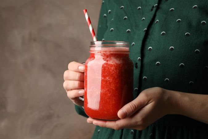 Woman hold glass jar of strawberry cocktail, close up. Summer drink