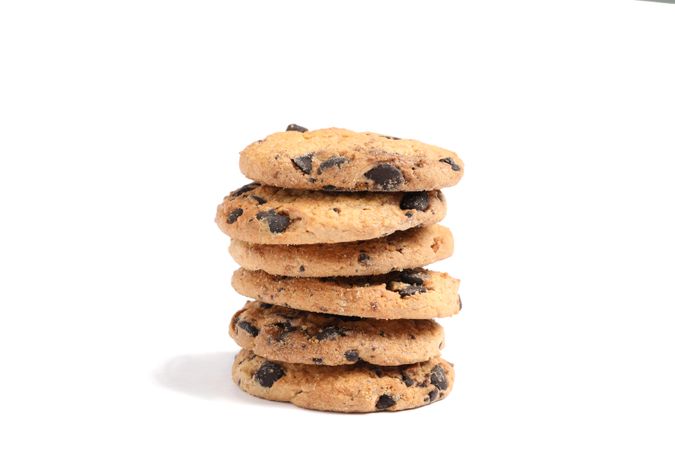 Stack of tasty chocolate chip cookies on studio background
