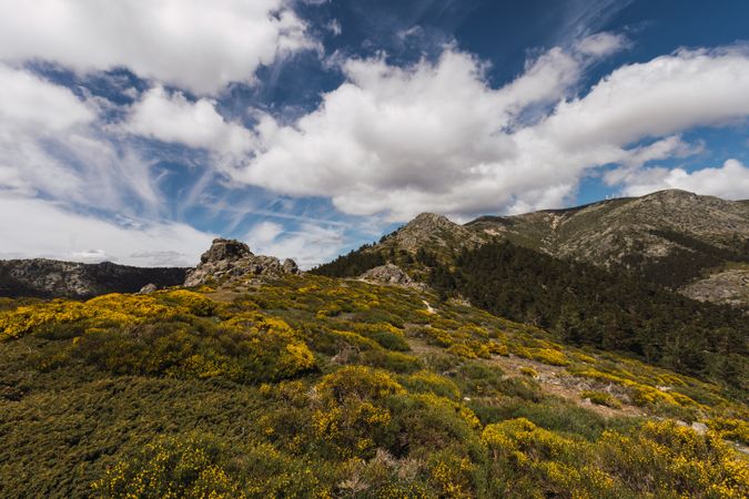 Breathtaking white clouds above hills with greenery