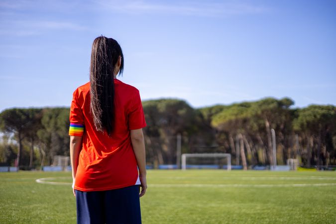 Back of female soccer player with captain armband with LGBT pride flag