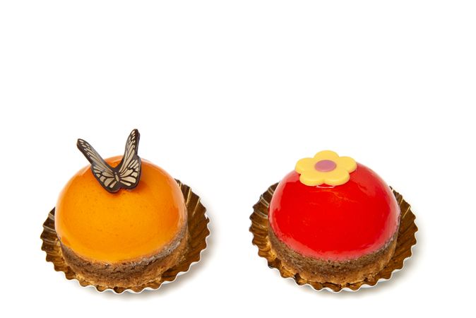 Two delicious looking small round cakes isolated on a plain background with space for copy