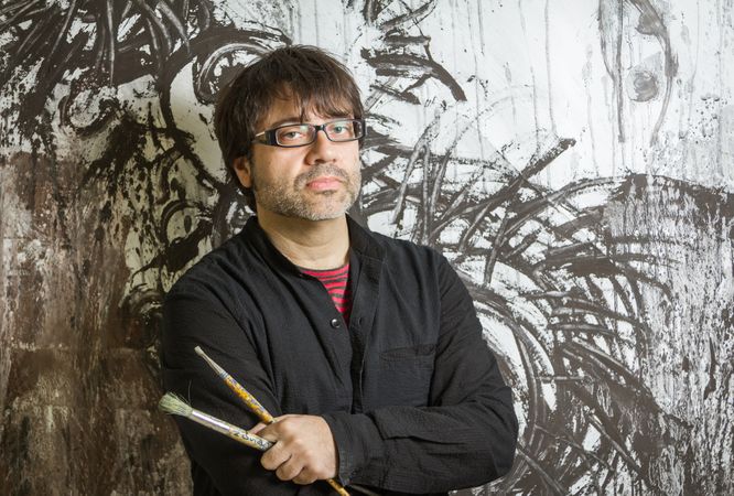 Painter artist posing in front of paint