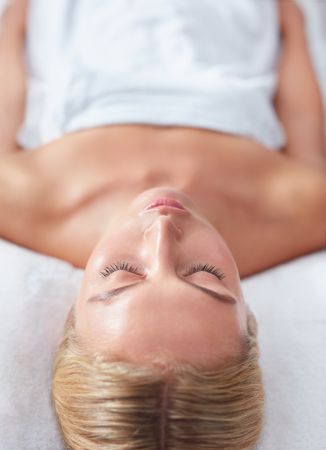 Blonde woman lying back and relaxing after treatment