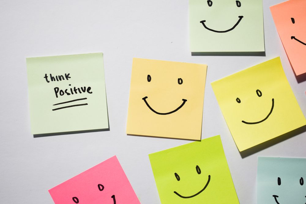 Think Positive and smile emoticon on sticky notes