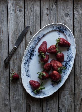 Plate with strawberries near napkin and knife