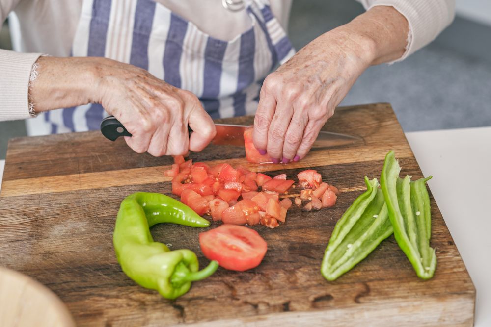 Unrecognizable woman cutting ripe tomatoes