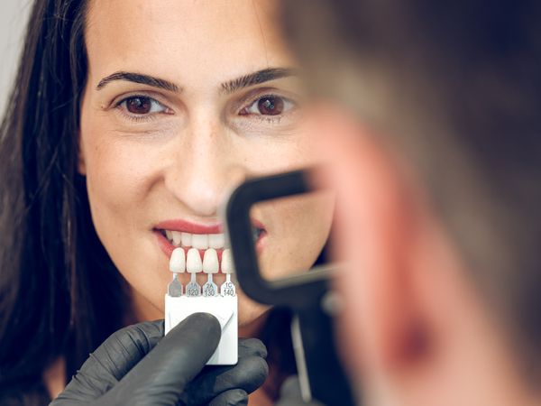 Female client during determining teeth shade