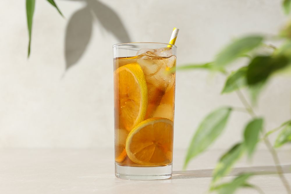 A glass of delicious cold tea on a plain background