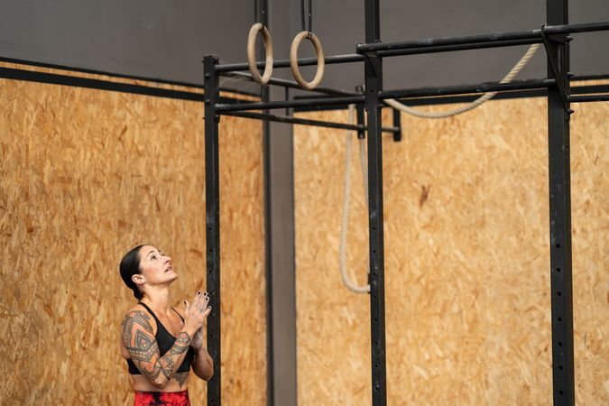Woman looking up at gymnastic rings in the gym