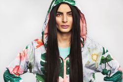 Confident woman pictured in colorful printed floral hoodie with her hands on her hips